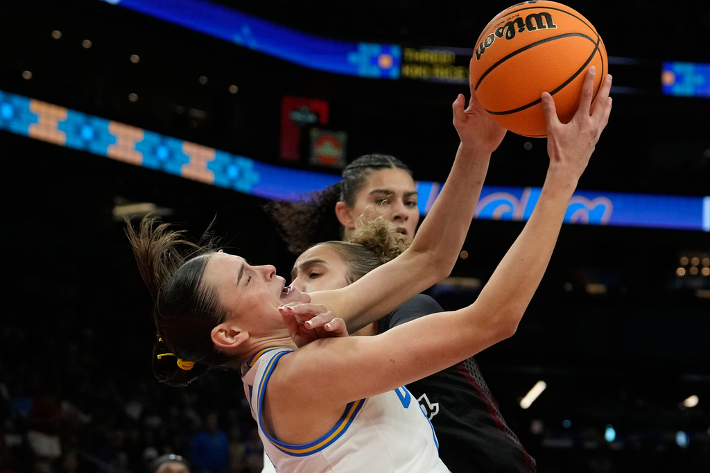 UCLA guard Gabriela Jaquez (11) grabs a rebound over South Carolina guard Tessa Johnson (5) during the second half of the women's National Championship Final Four NCAA college basketball tournament game, Sunday, April 5, 2026, in Phoenix. (AP Photo/Ross D. Franklin)