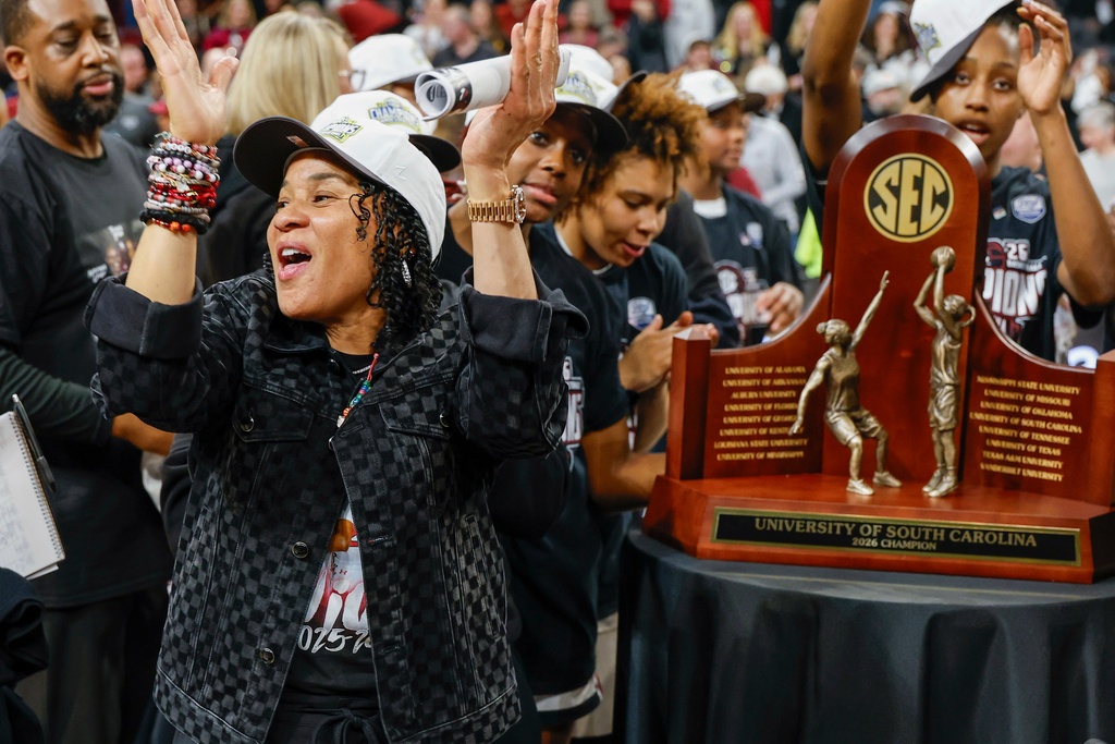 South Carolina head coach Dawn Staley, front left, claps during a ceremony presenting the SEC regular season champions trophy to her team after an NCAA college basketball game against Missouri in Columbia, S.C., Thursday, Feb. 26, 2026. (AP Photo/Nell Redmond)