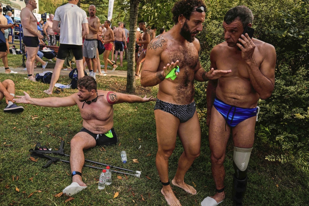 Ukrainian war veterans Oleksandr Dashko, from left, Oleh Tserkovnyi and Pavlo Tovstyk, prepare to compete in a 6.5km swimming race across the Bosporus Strait, from the Asian side to the European side, in Istanbul, Turkey, Sunday, Aug. 24, 2025. (AP Photo/Khalil Hamra)