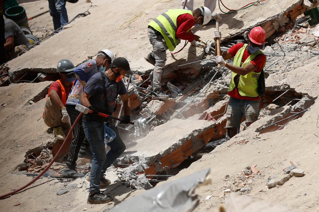 Rescue worker search through the rubble of a collapsed building two days after earthquakes struck Caracas, Venezuela, Friday, June 26, 2026. (AP Photo/Pedro Mattey)