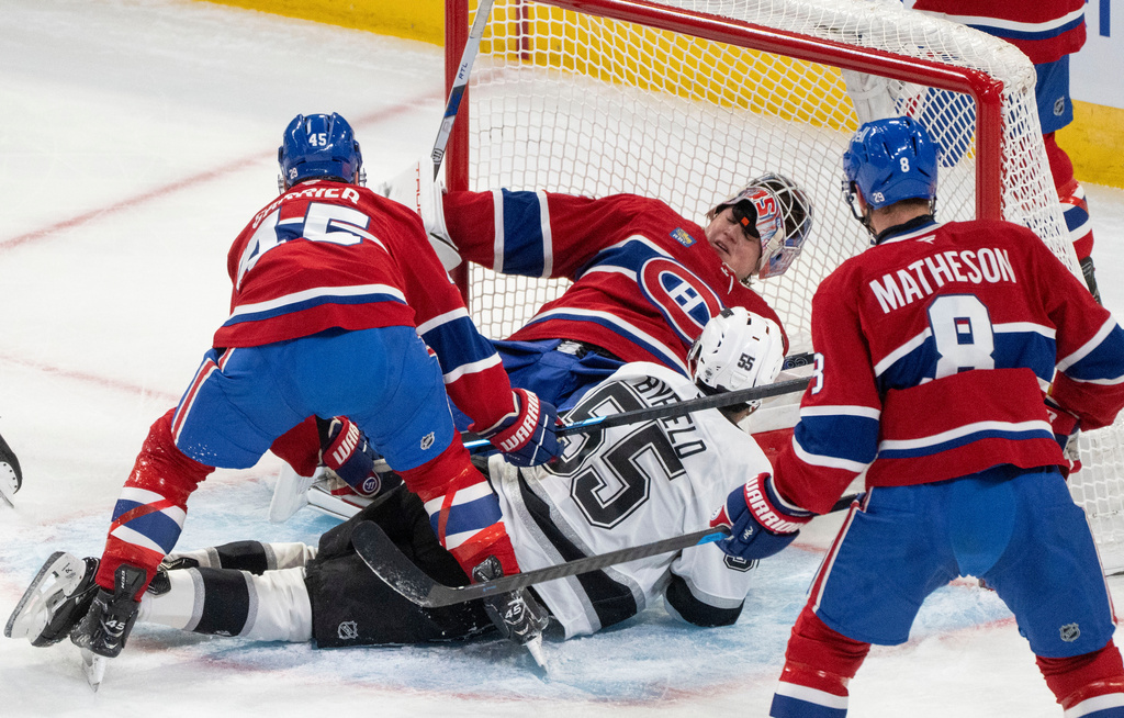 Montreal Canadiens goaltender Sam Montembeault (35) loses his mask as Los Angeles Kings' Quinton Byfield (55) slides into him during first period NHL hockey action in Montreal on Tuesday, Nov. 11, 2025. (Christinne Muschi/The Canadian Press via AP)