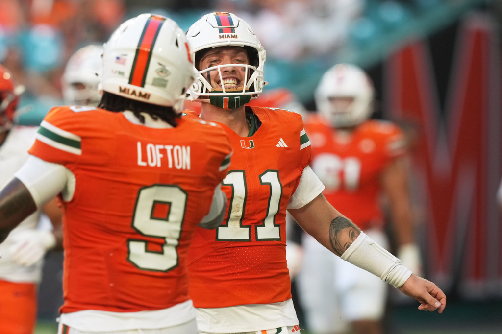Miami quarterback Carson Beck (11) celebrates after scoring a touchdown during the first half of an NCAA college football game against Syracuse Saturday, Nov. 8, 2025, in Miami Gardens, Fla. (AP Photo/Marta Lavandier)