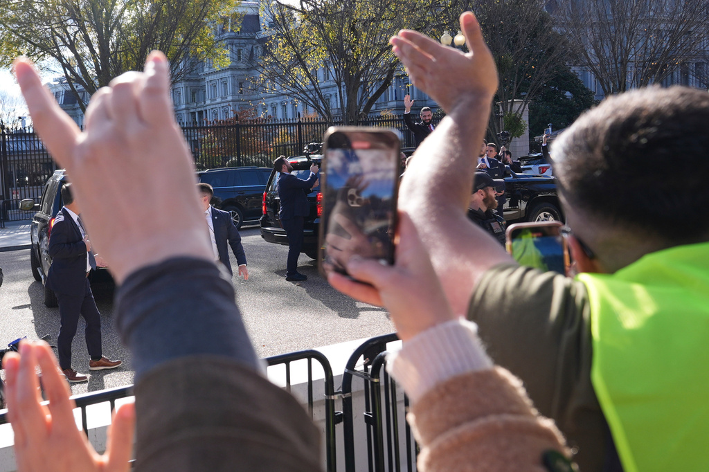 Syria's President Ahmed al-Sharaa, center, waves to supporters from a vehicle outside of the White House, Monday, Nov. 10, 2025, in Washington, following al-Sharaa's meeting with President Donald Trump. (AP Photo/Jacquelyn Martin)