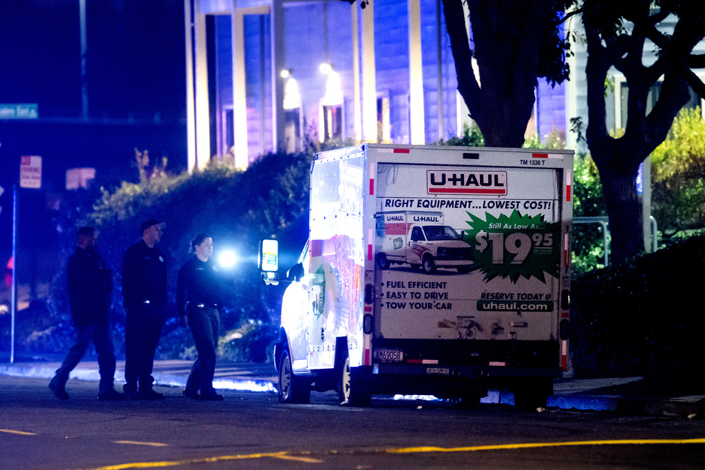 Police officers examine a U-Haul truck involved in a shooting at the entrance to Coast Guard Base Alameda, according to an officer at the scene, Friday, Oct. 24, 2025, in Oakland, Calif. (AP Photo/Noah Berger)