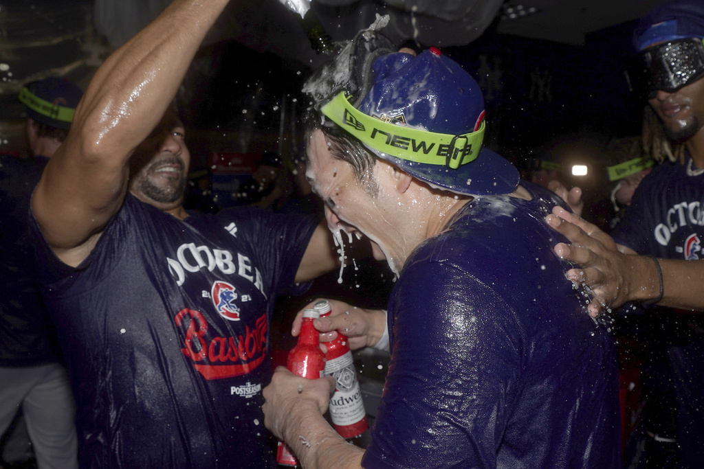 Chicago Cubs assistant hitting coach Juan Cabreja, left, celebrates with Seiya Suzuki, right, in the clubhouse after the Cubs clinched a playoff berth after defeating the Pittsburgh Pirates in a baseball game Wednesday, Sept. 17, 2025, in Pittsburgh. (AP Photo/Matt Freed)