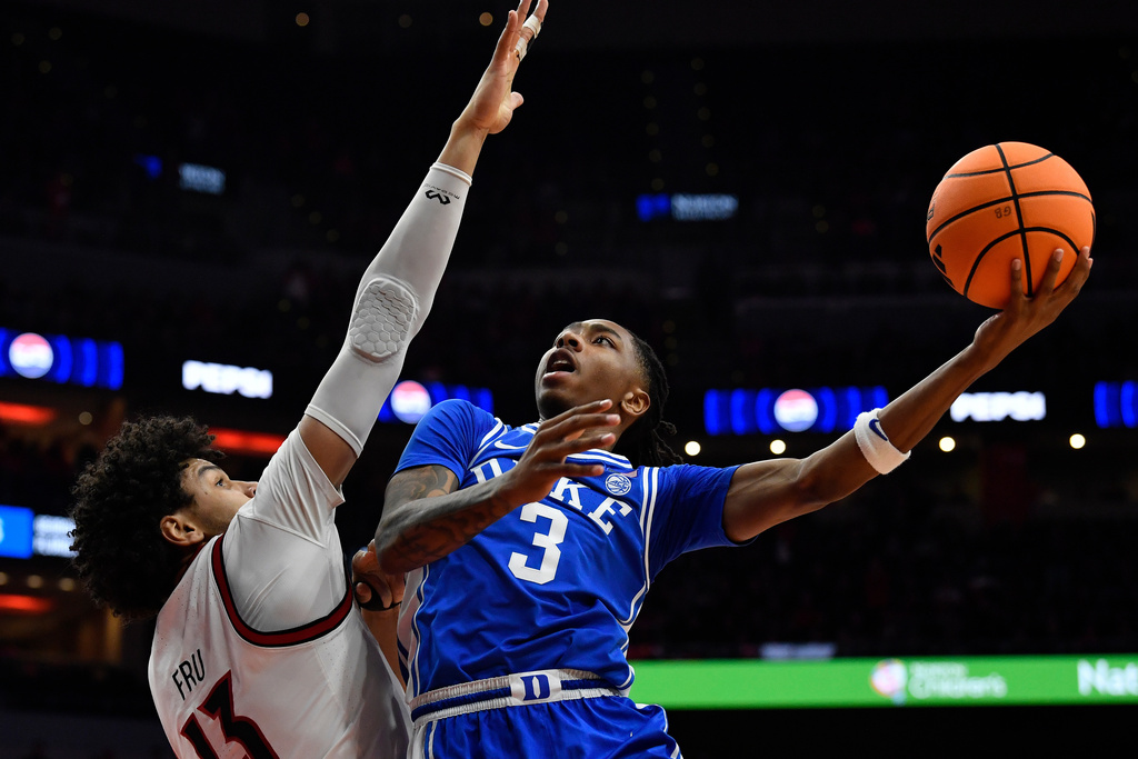 Duke guard Isaiah Evans (3) attempts a layup over Louisville forward Sananda Fru (13) during the first half of an NCAA college basketball game in Louisville, Ky., Tuesday, Jan. 6, 2026. (AP Photo/Timothy D. Easley)