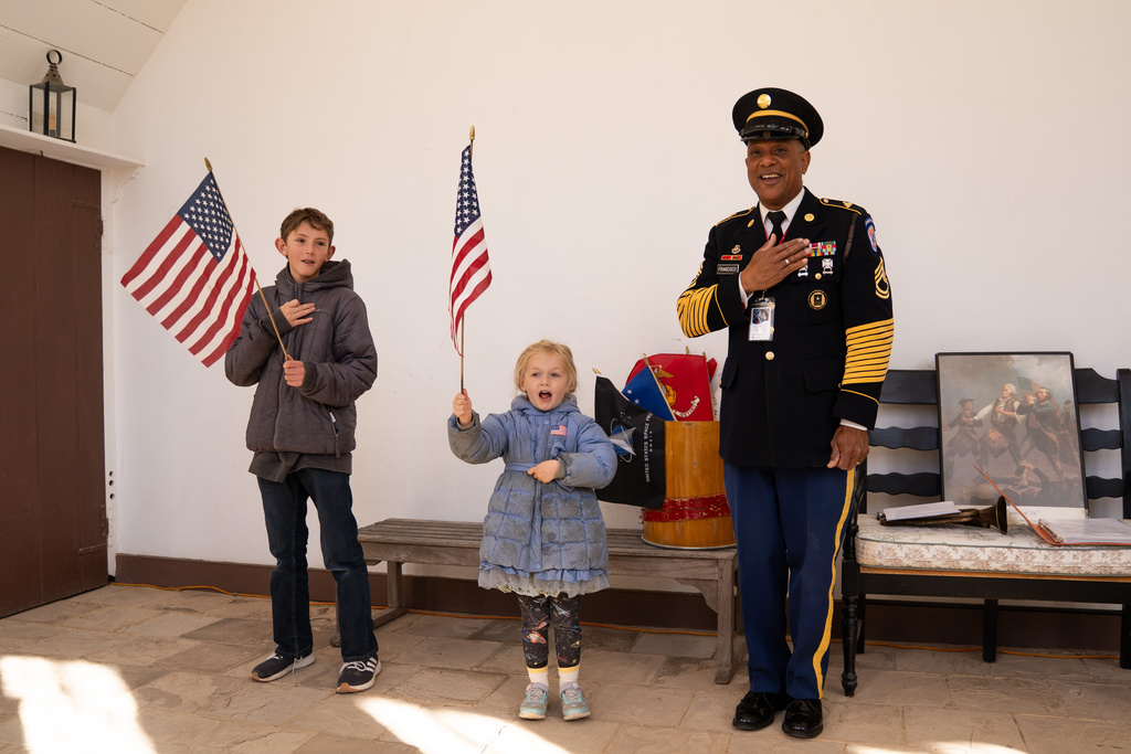 Resident Fifer Donald Francisco leads children in the pledge of allegiance at George Washington's Mount Vernon to commemorate Veterans Day, Tuesday, Nov. 11, 2025, in Mt. Vernon, Va. (AP Photo/Allison Robbert)