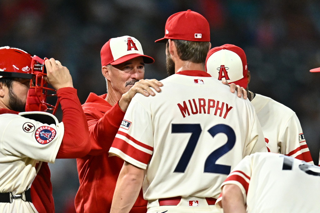 Los Angeles Angels pitcher Luke Murphy (72) speaks with pitching coach Mike Maddux, second from left, during the eighth inning of a baseball game against the Milwaukee Brewers, Friday, July 31, 2026, in Anaheim, Calif. (AP Photo/William Liang)
