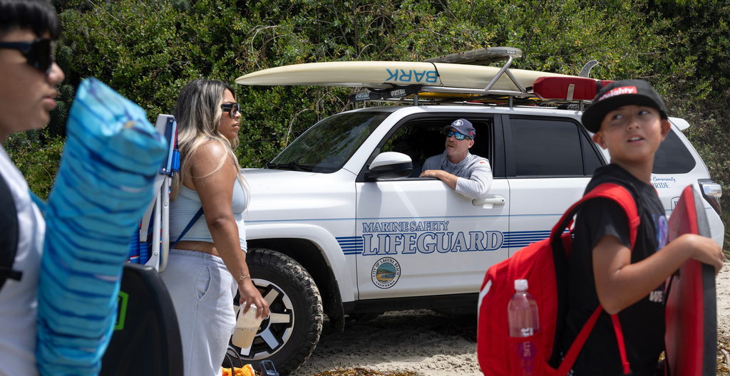 Laguna Beach Marine Safety Officer Avery Wickham breaks the news to beach-goers that they will not be allowed into the water because of dangerous conditions at the beach near Montage Resort on Wednesday, June 10, 2026, Laguna Beach, Calif. (Mindy Schauer/The Orange County Register via AP)
