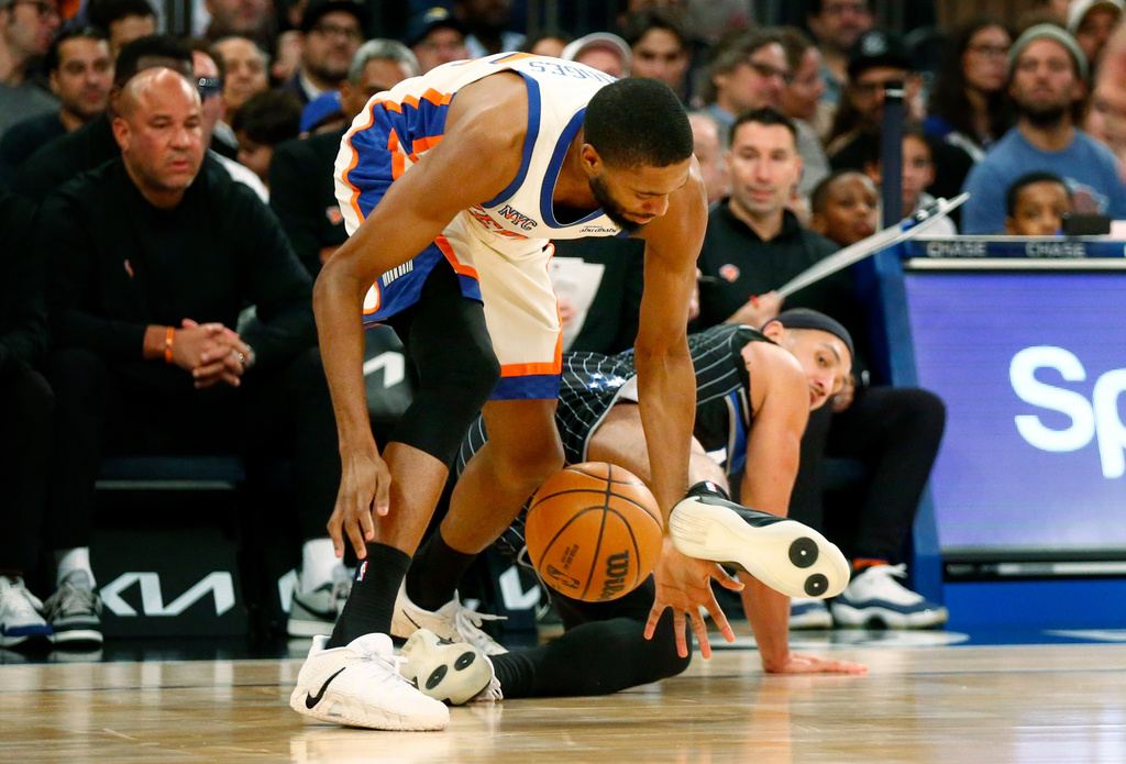 New York Knicks guard Mikal Bridges goes for a loose ball as Orlando Magic guard Jalen Suggs defends during the first half of an NBA basketball game Sunday, Dec. 7, 2025, in New York. (AP Photo/John Munson)