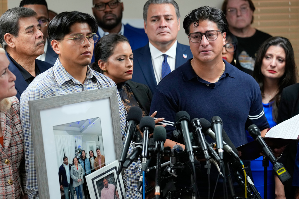 Ronaldo Salgado, right, son of Lorenzo Salgado Araujo, speaks as his brother, Lorenzo Jr. holds family photographs during a news conference Wednesday, July 8, 2026, in Houston. (AP Photo/David J. Phillip)