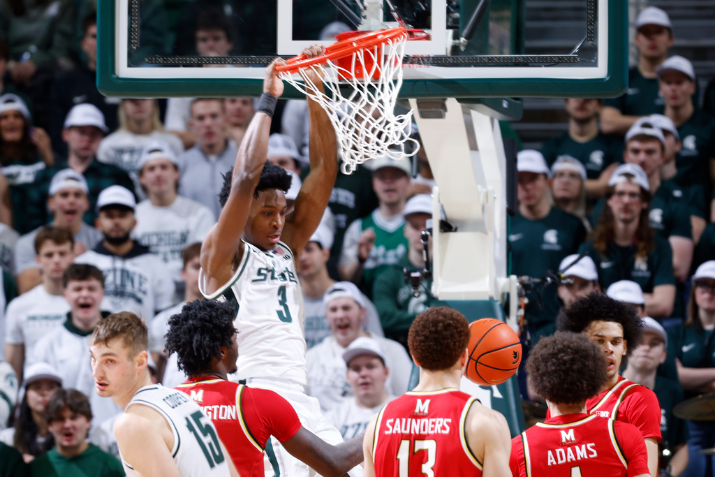 Michigan State forward Cam Ward (3) dunks over Maryland forward Solomon Washington, left, forward Elijah Saunders (13) and guard Darius Adams, right, during the first half of an NCAA college basketball game, Saturday, Jan. 24, 2026, in East Lansing, Mich. (AP Photo/Al Goldis)