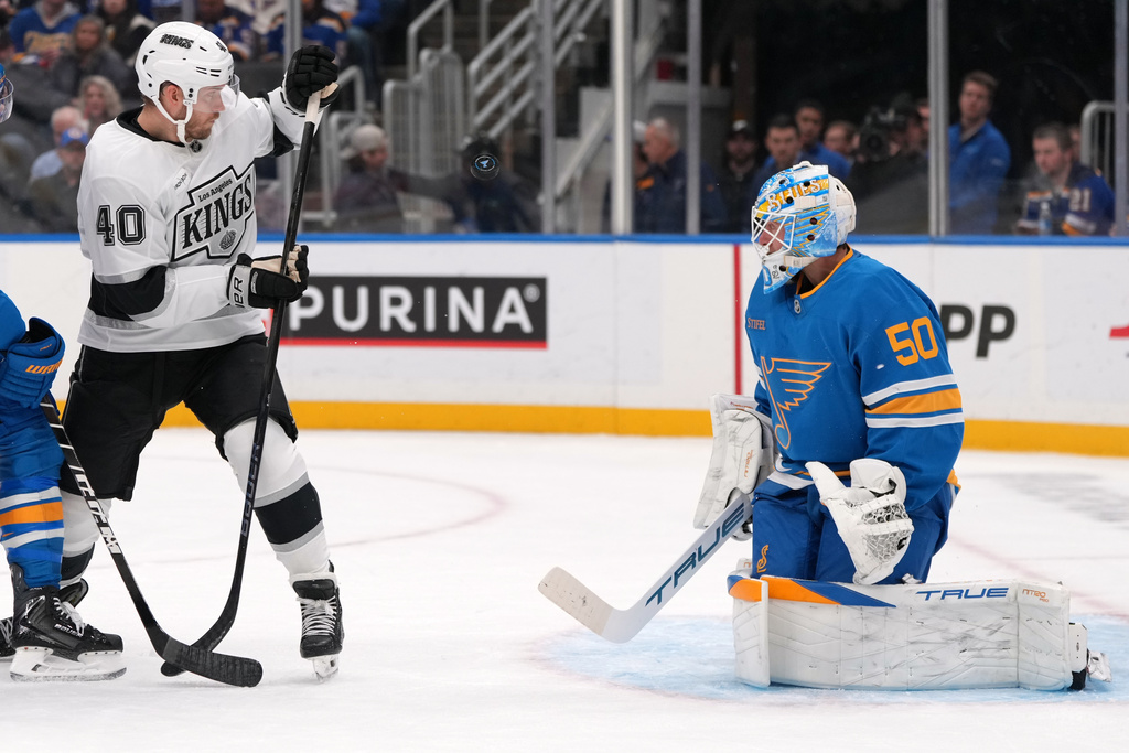 St. Louis Blues goaltender Jordan Binnington (50) and Los Angeles Kings' Joel Armia (40) watch a puck fly through the air during the first period of an NHL hockey game Tuesday, Oct. 21, 2025, in St. Louis. (AP Photo/Jeff Roberson)