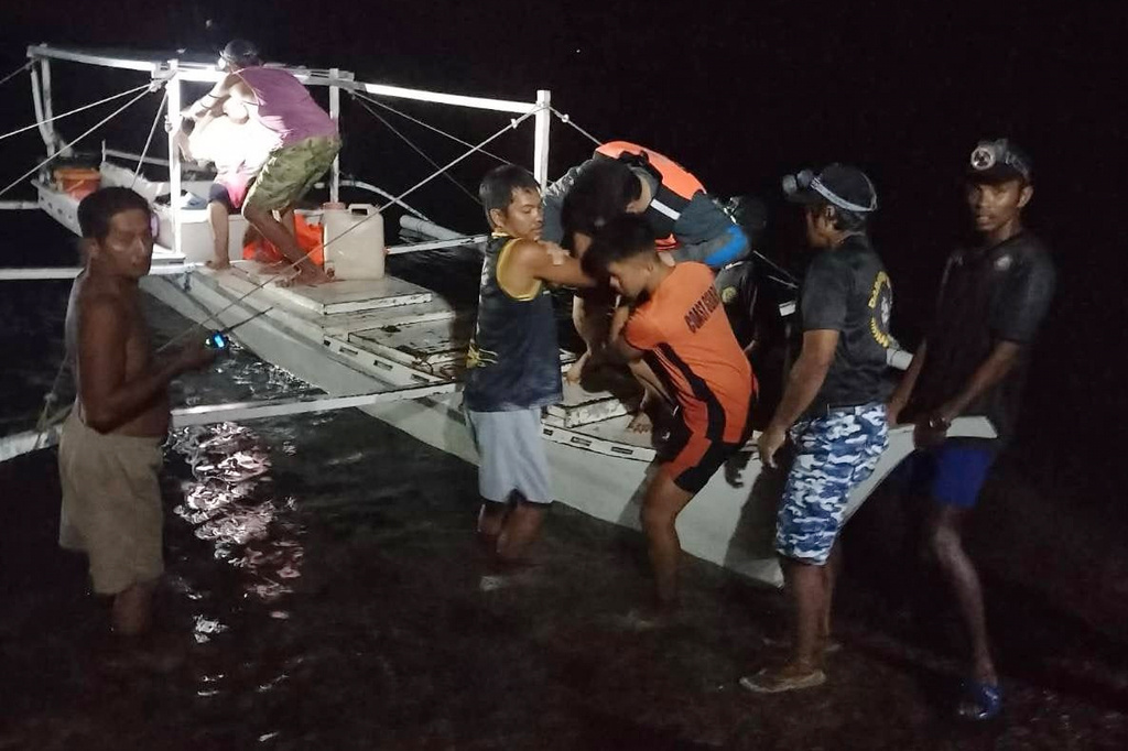 In this image provided by the Philippine Coast Guard, a survivor is assisted as he alights from a small boat after being rescued from a burning ferry off Palawan province, Philippines on Wednesday Sept. 9, 2026. (Philippine Coast Guard via AP)