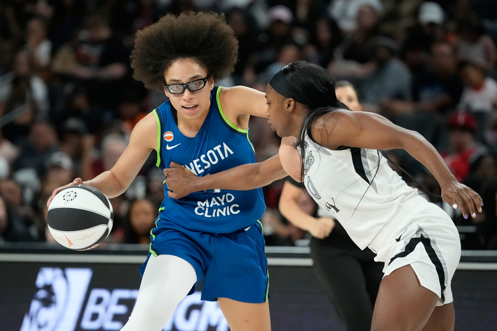 Minnesota Lynx guard Olivia Miles (5) drives against Las Vegas Aces guard Jackie Young (0) during the second half of a WNBA basketball game Saturday, June 13, 2026, in Las Vegas. (AP Photo/John Locher)