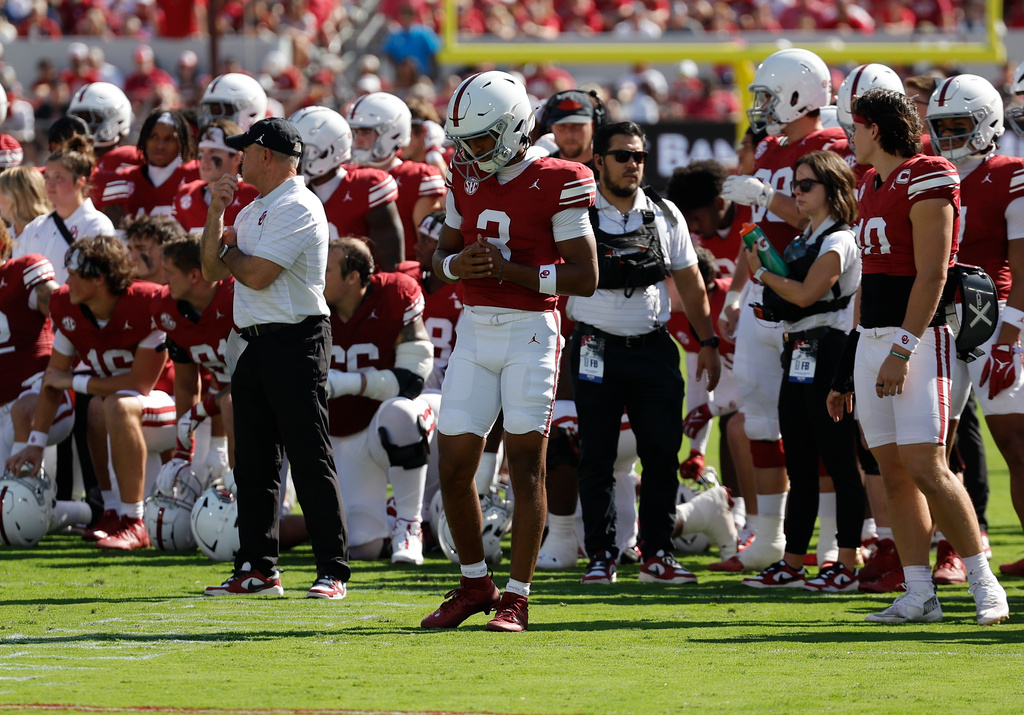Oklahoma quarterback Michael Hawkins Jr., center, and the team take a moment after teammate Keontez Lewis was injured during the first half of an NCAA college football game against Kent State, Saturday, Oct. 4, 2025, in Norman, Okla. (AP Photo/Alonzo Adams)