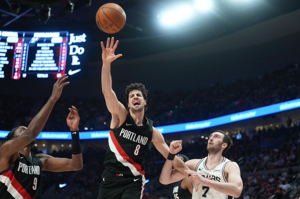 Portland Trail Blazers forward Deni Avdija (8) goes for the ball as San Antonio Spurs center/forward Luke Kornet (7) looks on during the first half in Game 4 of a first-round NBA basketball playoffs series in Portland, Ore., Sunday, April 26, 2026. (AP Photo/Jenny Kane)