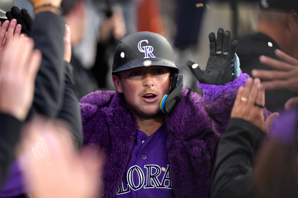 Colorado Rockies' Hunter Goodman is congratulated by teammates in the dugout after hitting a solo home run during the second inning of a baseball game against the Los Angeles Dodgers, Tuesday, May 26, 2026, in Los Angeles. (AP Photo/Mark J. Terrill)