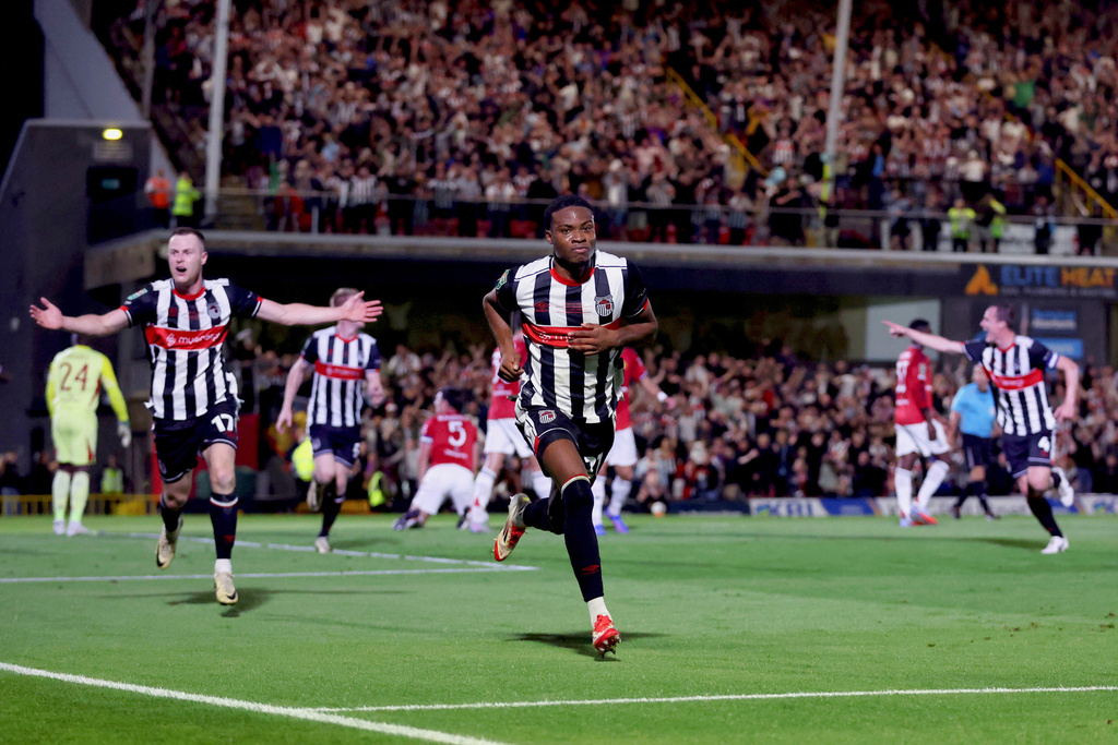 Grimsby Town's Tyrell Warren, center, celebrates scoring their side's second goal during an English League Cup second round soccer match against Manchester United, Wednesday, Aug. 27, 2025, at Hill Blundell Park in Grimsby, England. (Nigel French/PA via AP)