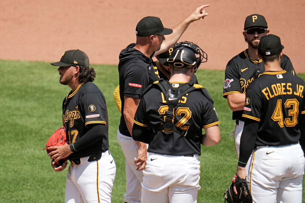 Pittsburgh Pirates pitcher Jared Jones, left, walks off the mound after handing the ball to manager Don Kelly, second from left, during the fourth inning of a baseball game against the New York Mets in Pittsburgh, Sunday, Aug. 9, 2026. (AP Photo/Gene J. Puskar)