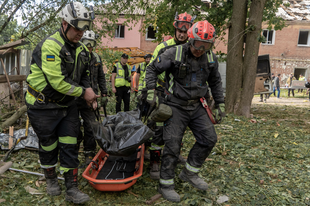 Rescuers carry a body that they removed from under the rubble of an apartment building following Russia's missile attack in Kharkiv, Ukraine, Saturday, June 20, 2026. (AP Photo/Andrii Marienko)