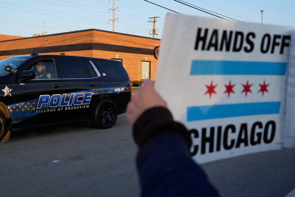 A police guards the designated protest area as protesters gather outside an ICE processing facility in the Chicago suburb of Broadview, Ill., Friday, Oct. 31, 2025. (AP Photo/Nam Y. Huh)