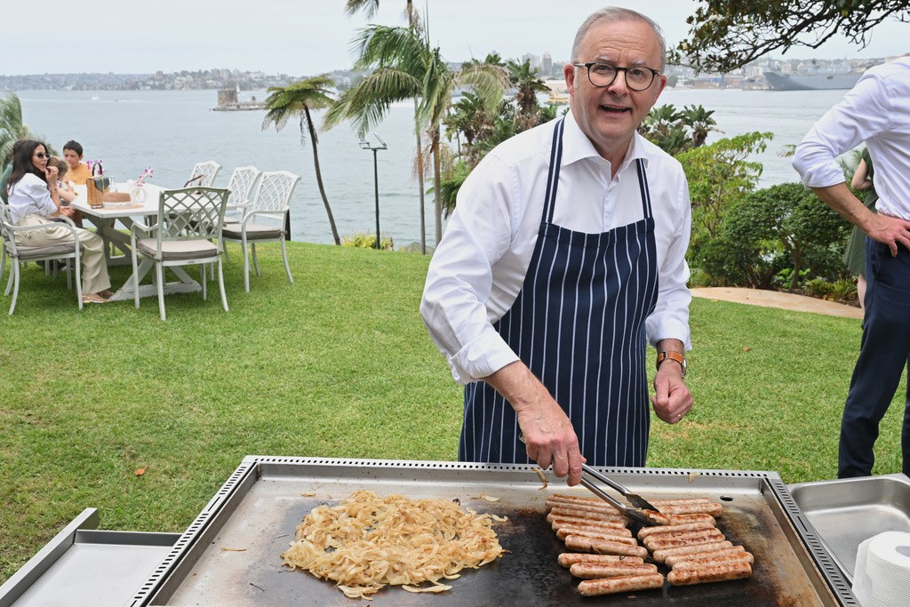 Australian Prime Minister Anthony Albanese reacts as he cooks on a barbecue at an event to mark the beginning of the social media ban for children under 16 years of age, at Kirribilli House, in Sydney, Australia, Wednesday, Dec. 10, 2025. (Mick Tsikas/AAP Image via AP)