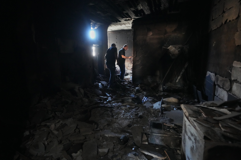 Resident Samih Haidar, right, inspects his burned apartment damaged in Israeli strikes in the southern port city of Tyre, Lebanon, Thursday, June 18, 2026. (AP Photo/Hassan Ammar)