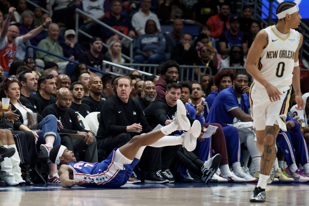Philadelphia 76ers guard Vj Edgecombe, front left, falls backward after making a 3-point basket near to New Orleans Pelicans guard Jeremiah Fears (0) during the first half of an NBA basketball game in New Orleans, Saturday, Feb. 21, 2026. (AP Photo/Matthew Hinton)