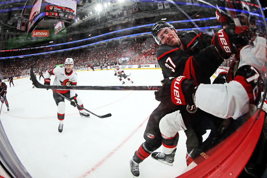 Carolina Hurricanes' Andrei Svechnikov (37) checks Ottawa Senators' Thomas Chabot (72) into the boards during the second period of Game 2 of an NHL hockey Stanley Cup first-round playoff series in Raleigh, N.C., Monday, April 20, 2026. (AP Photo/Karl DeBlaker)