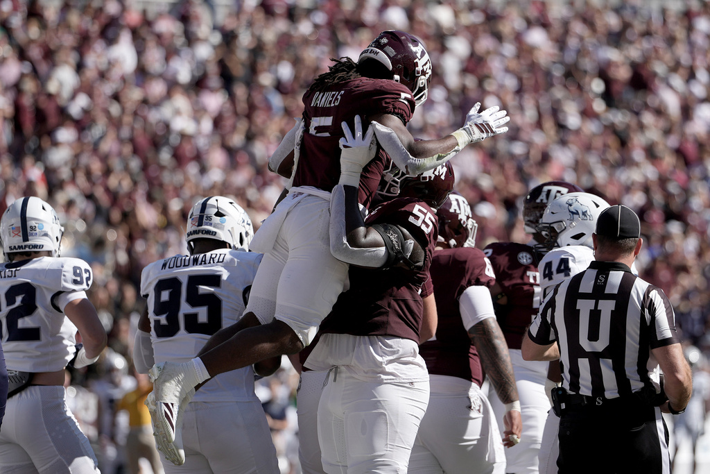 Texas A&M offensive lineman Ar'Maj Reed-Adams (55) lifts up running back Amari Daniels (5) after he scored a touchdown against Samford during the second quarter of an NCAA college football game Saturday, Nov. 22, 2025, in College Station, Texas. (AP Photo/Sam Craft)