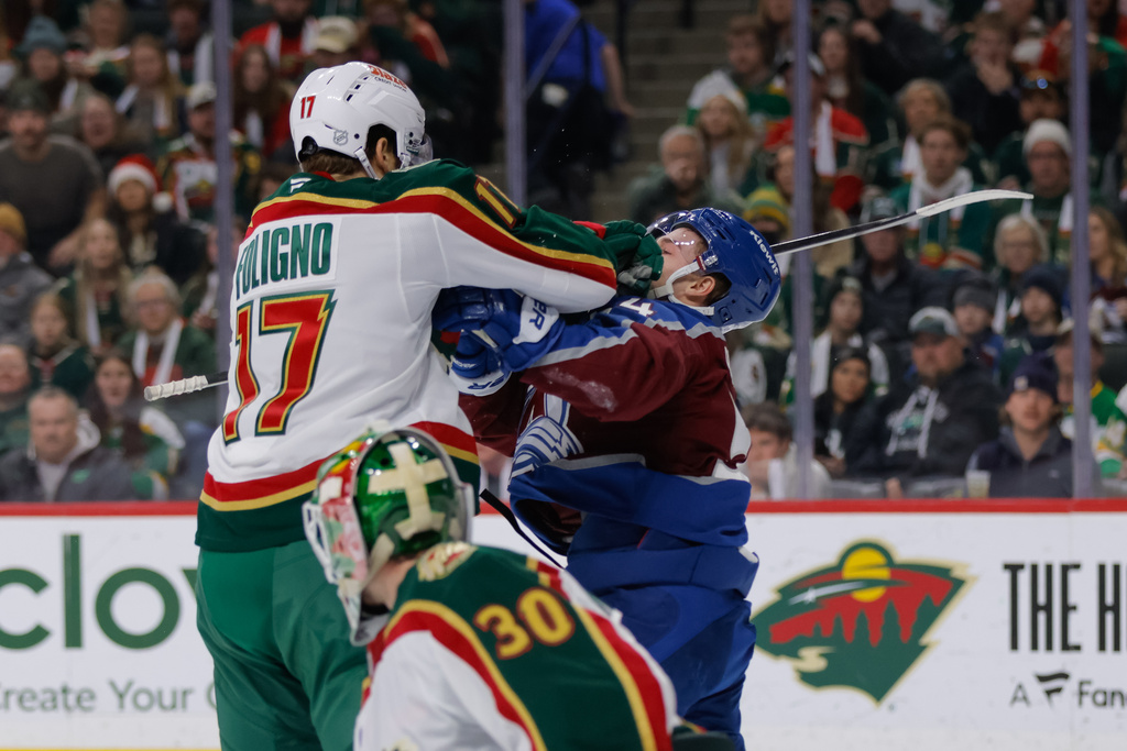Minnesota Wild left wing Marcus Foligno (17) cross checks Colorado Avalanche center Gavin Brindley during the second period of an NHL hockey game, Sunday, Dec. 21, 2025, in St. Paul, Minn. (AP Photo/Bailey Hillesheim)