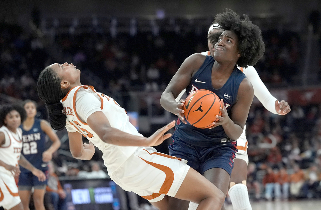 Penn center Tina Njike fouls Texas forward Madison Booker during the first half of an NCAA college basketball game in Austin, Texas, Sunday, Nov. 30, 2025. (AP Photo/Rodolfo Gonzalez)