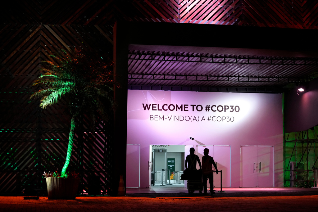 People work in front of the entrance of the press center for the upcoming COP30 U.N. Climate Summit, in Belem, Brazil, Monday, Nov. 3, 2025. (AP Photo/Eraldo Peres)