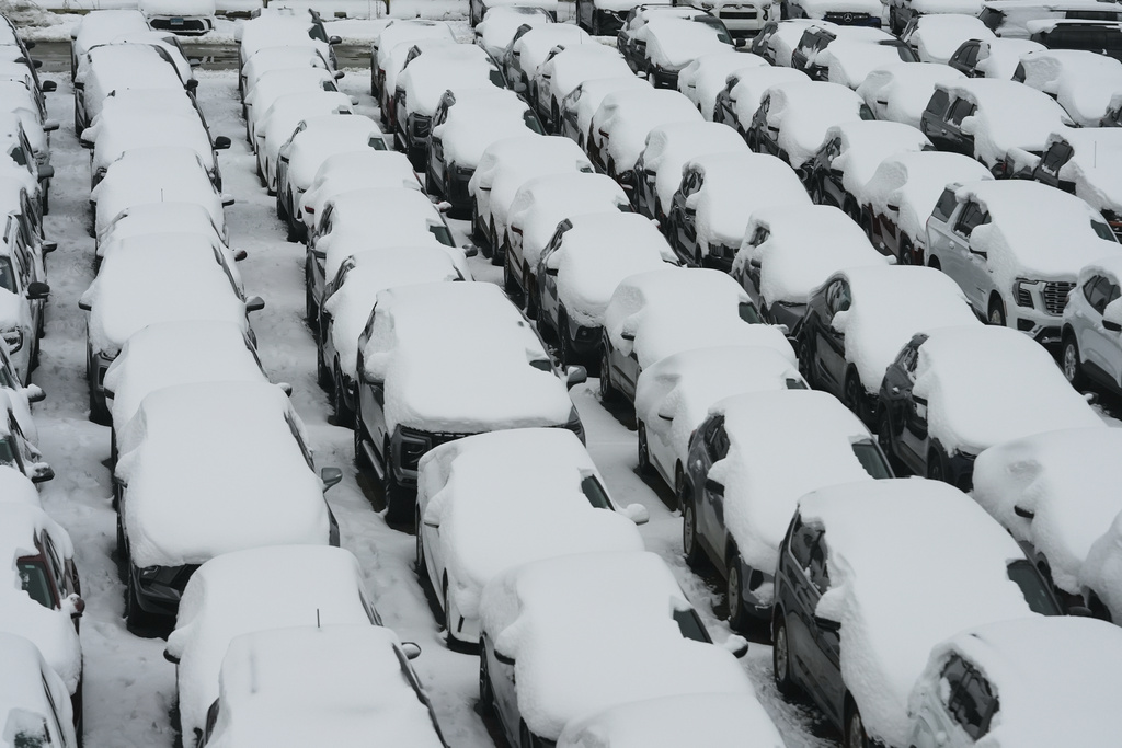 Snow covered vehicles sit in a rental car parking lot at O'Hare International Airport in Chicago, Sunday, Nov. 30, 2025. (AP Photo/Nam Y. Huh)