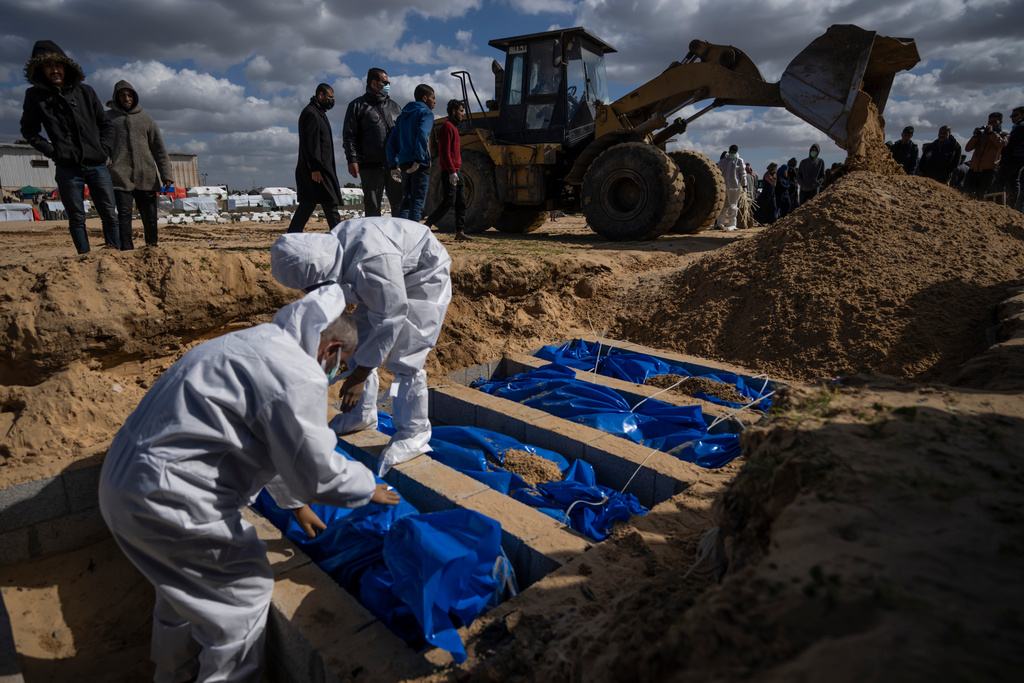 Palestinians bury the bodies of people who were killed in fighting with Israel and returned to Gaza by the Israeli military, during a mass funeral in Rafah, Gaza Strip, Tuesday, Jan. 30, 2024. (AP Photo/Fatima Shbair)