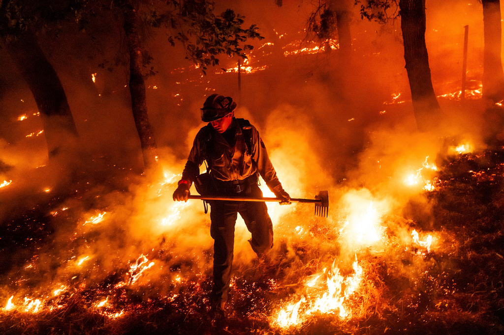 FILE - A firefighter battles the Pickett Fire burning in the Aetna Springs area of Napa County, Calif., Aug. 23, 2025. (AP Photo/Noah Berger, File)
