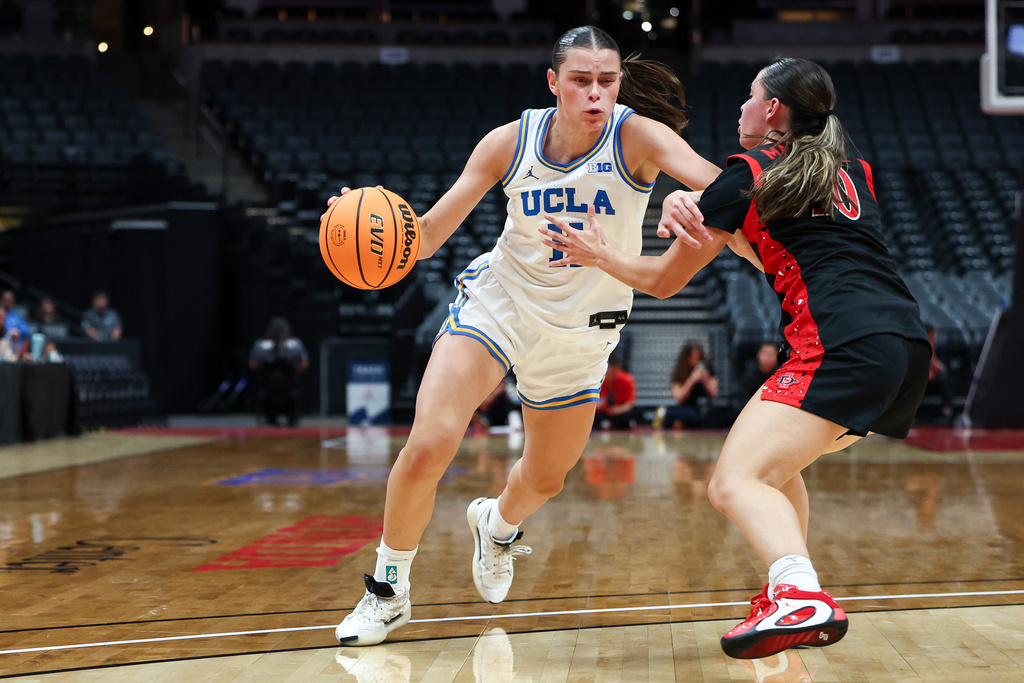 UCLA forward Gabriela Jaquez, left, drives against San Diego State guard Nat Martinez, right, during the first half of an NCAA college basketball game, Monday, Nov. 3, 2025, in Anaheim, Calif. (AP Photo/Jessie Alcheh)