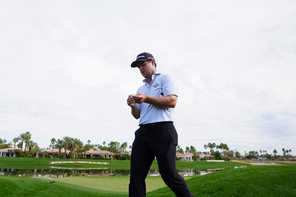 Pierceson Coody looks at his golf ball as he walks off the 18th green during the first round of the American Express golf event at Jack Nicklaus Tournament Course at PGA West Thursday, Jan. 22, 2026, in La Quinta, Calif. (AP Photo/Ross D. Franklin)