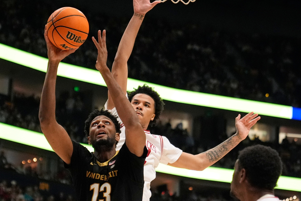 FILE - Vanderbilt forward Jalen Washington (13) shoots the ball past Arkansas forward Malique Ewin, right, during the first half of an NCAA college basketball game in the final of the Southeastern Conference tournament March 15, 2026, in Nashville, Tenn. (AP Photo/George Walker IV, File)