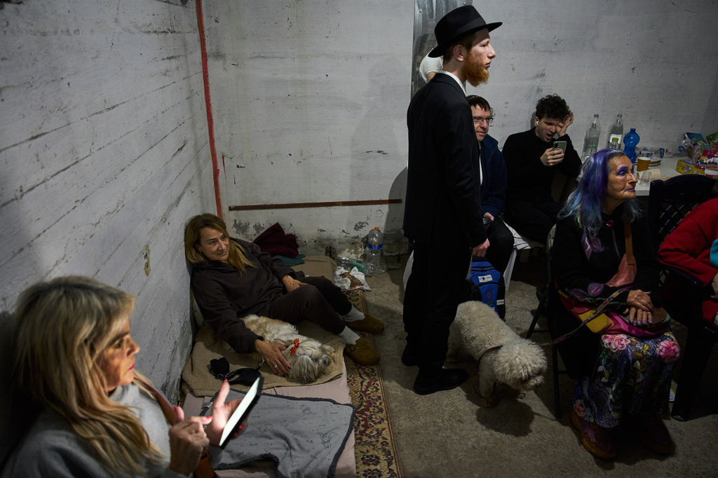 People take cover in a bomb shelter as air raid sirens warn of incoming Iranian missile strikes in Ramat Gan, Israel, Tuesday, April 7, 2026. (AP Photo/Oded Balilty)