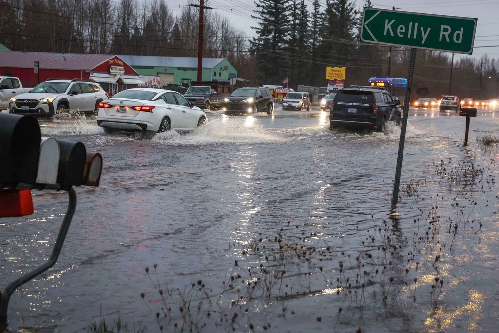 Motorists drive over flooded Guide Meridian Road in Northern Bellingham in Wash., Wednesday Dec. 10, 2025. (Ivy Ceballo/The Seattle Times via AP)