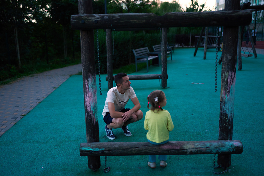 Volodymyr Bovsunovskyi talks to his daughter at the children's playground of their residential complex, the day after a Russian drone attack struck one of the buildings, in Kyiv, Wednesday, Sept. 2, 2026. (AP Photo/Francisco Seco)