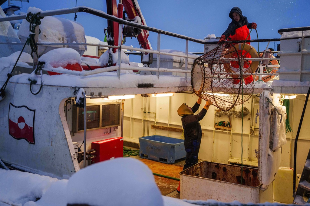 Fishermen load crab trap into a boat at the harbour of Nuuk, Greenland, on Monday, Jan. 19, 2026. (AP Photo/Evgeniy Maloletka)
