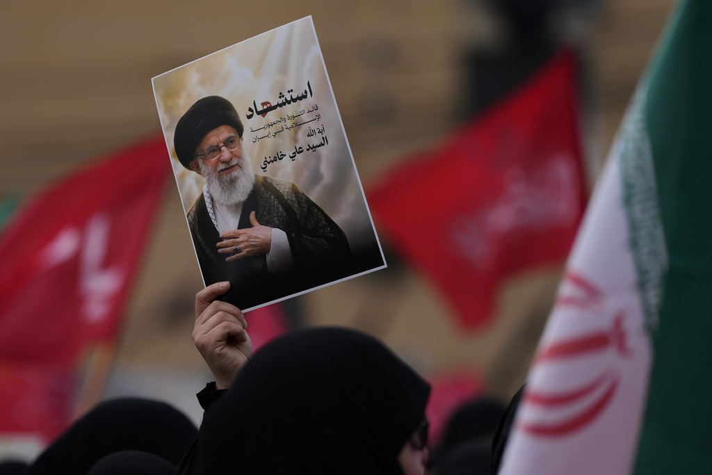 A Hezbollah supporter holds up a portrait of the late Iranian Supreme Leader Ayatollah Ali Khamenei during a gathering in the southern suburbs of Beirut, Lebanon, Sunday, March 1, 2026. The Arabic words on the portrait read:"Martyrdom of the leader of the Islamic revolution in Iran, sayyed Ayatollah Ali Khamenei." (AP Photo/Hassan Ammar)