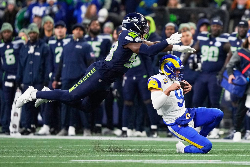 Los Angeles Rams quarterback Matthew Stafford (9) slides under Seattle Seahawks linebacker Boye Mafe (53) during the first half of the NFC Championship NFL football game Sunday, Jan. 25, 2026, in Seattle. (AP Photo/Stephen Brashear)