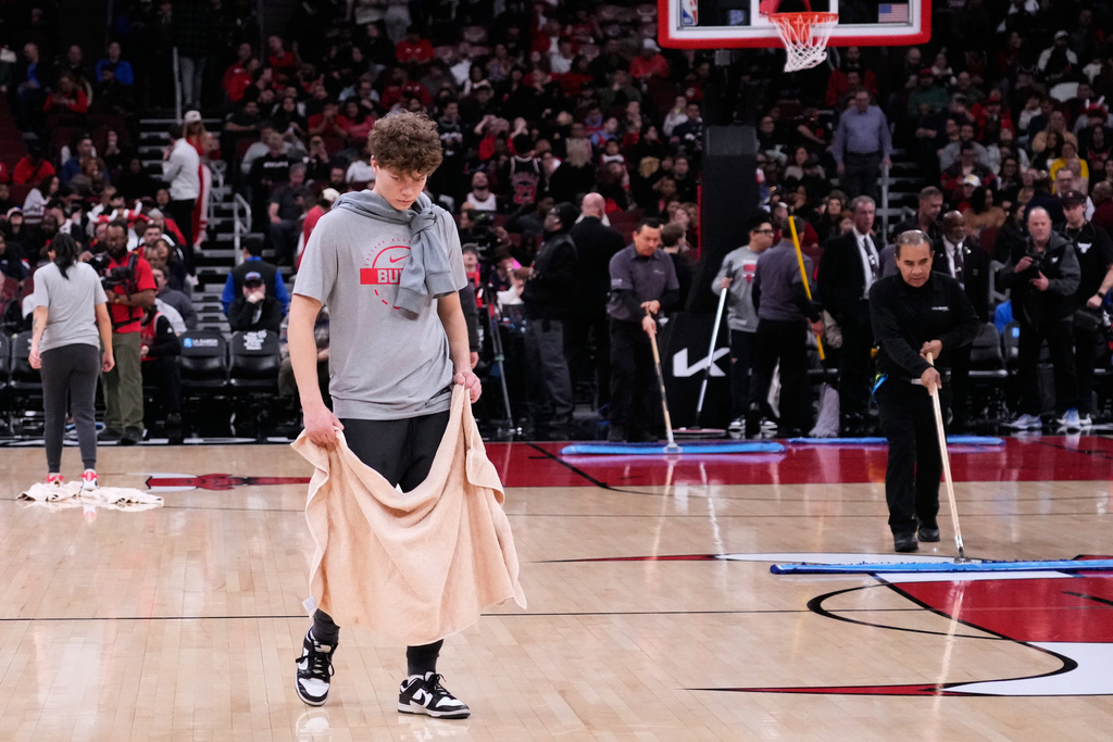 United Center employees try to dry the court before an NBA basketball game between the Miami Heat and the Chicago Bulls in Chicago, Thursday, Jan. 8, 2026. (AP Photo/Nam Y. Huh)