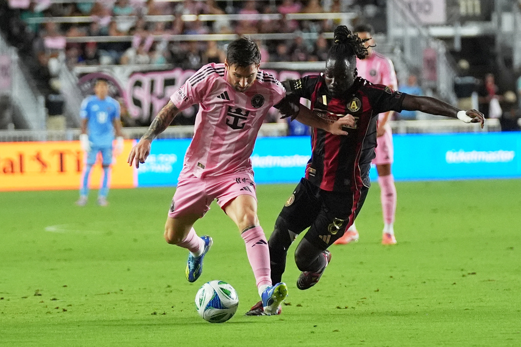 Inter Miami forward Lionel Messi, left, runs with the ball as Atlanta United midfielder Tristan Muyumba, right, defends during the first half of an MLS soccer match, Saturday, Oct. 11, 2025, in Fort Lauderdale, Fla. (AP Photo/Lynne Sladky)
