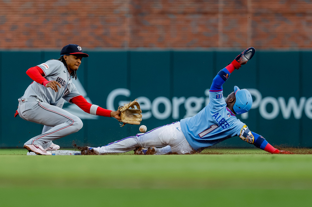 Atlanta Braves' Ozzie Albies (1) steals second base against Washington Nationals shortstop CJ Abrams (5) during the first inning of a baseball game, Saturday, Aug. 1, 2026, in Atlanta. (AP Photo/Erik S. Lesser)