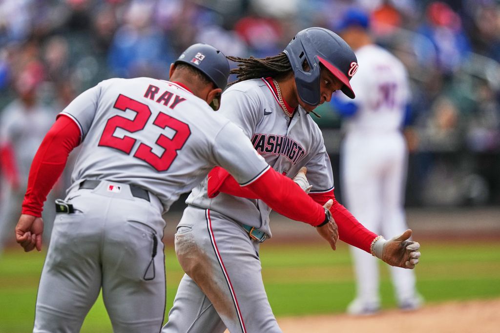 Washington Nationals' CJ Abrams, center, celebrates with first base coach Corey Ray, left, as he runs the bases after hitting a two run home run during the eighth inning of a baseball game Thursday, April 30, 2026, in New York. (AP Photo/Frank Franklin II)